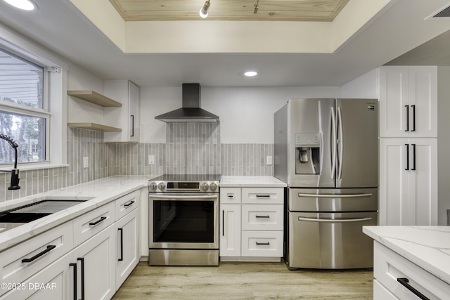 1704 Travelers Palm Dr, Edgewater, FL 32132 - kitchen featuring appliances with stainless steel finishes, wall chimney exhaust hood, a sink, white cabinetry, and light stone counters