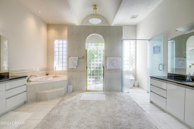 full bathroom featuring vanity, independent shower and bath, vaulted ceiling, tile patterned flooring, and toilet