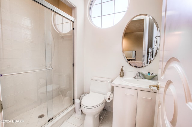 bathroom featuring toilet, vanity, tile patterned floors, and a shower with shower door