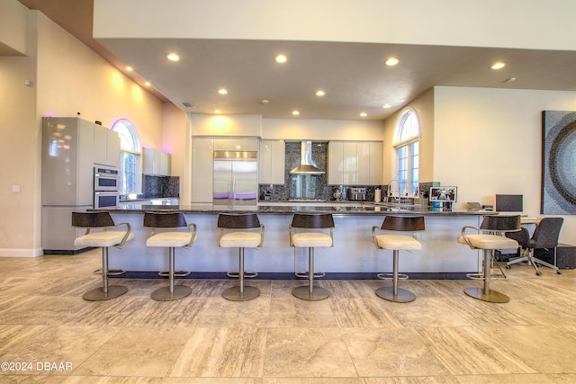 2540 Taxiway Echo, Port Orange, FL 32128 - kitchen with stainless steel appliances, wall chimney exhaust hood, a peninsula, tasteful backsplash, and recessed lighting