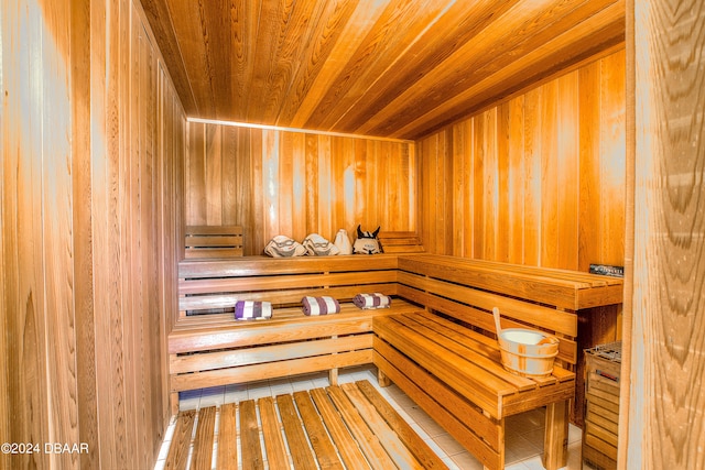 view of sauna featuring wooden ceiling and wooden walls