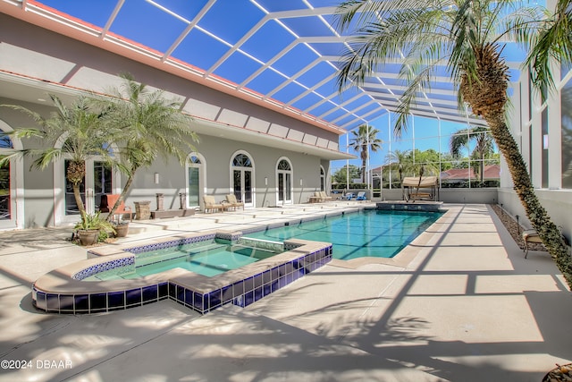 view of pool with a lanai, an in ground hot tub, and a patio area