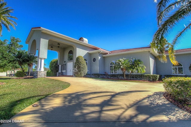 mediterranean / spanish-style house featuring a front yard