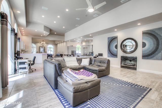 living room featuring ceiling fan with notable chandelier