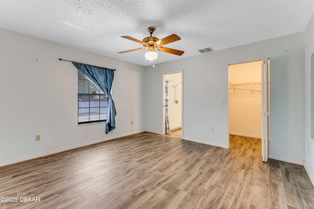 unfurnished bedroom featuring a textured ceiling, visible vents, and light wood-type flooring