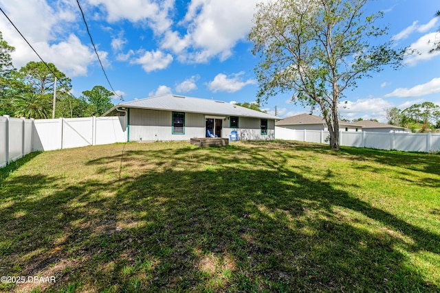 back of house featuring a lawn and a fenced backyard