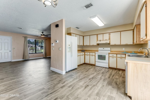 kitchen with under cabinet range hood, visible vents, a sink, white appliances, and light wood-style flooring