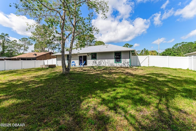 back of house with a fenced backyard and a yard
