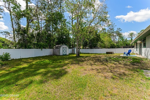 view of yard with a fenced backyard, an outdoor structure, and a storage shed