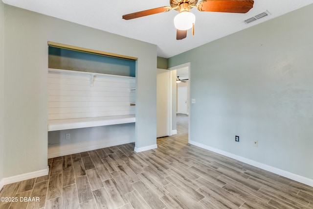 interior space with baseboards, wood finished floors, visible vents, and a closet