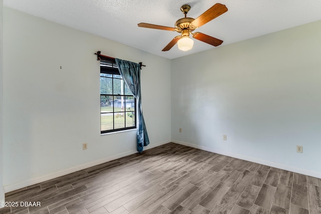 unfurnished room with wood finished floors, baseboards, and ceiling fan