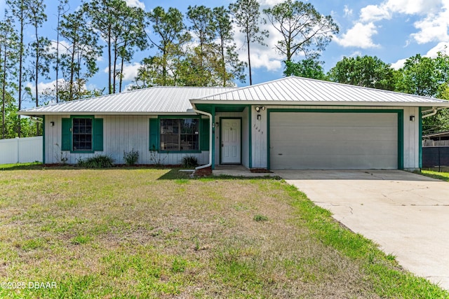 ranch-style home with a front lawn, driveway, metal roof, fence, and an attached garage