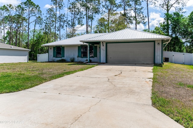 single story home with central AC, a garage, concrete driveway, a front lawn, and metal roof