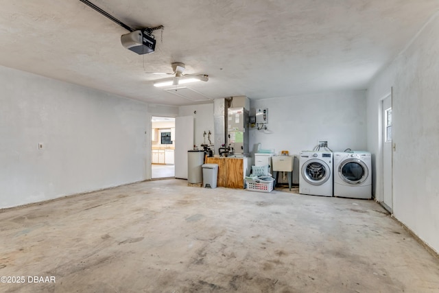 garage with heating unit, a garage door opener, and separate washer and dryer