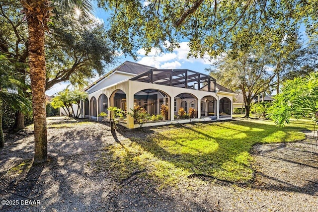 back of house with a yard and a lanai