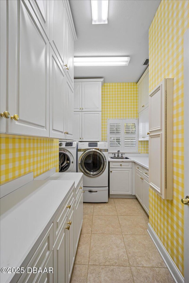 laundry room featuring light tile patterned flooring, cabinets, sink, and washer and dryer