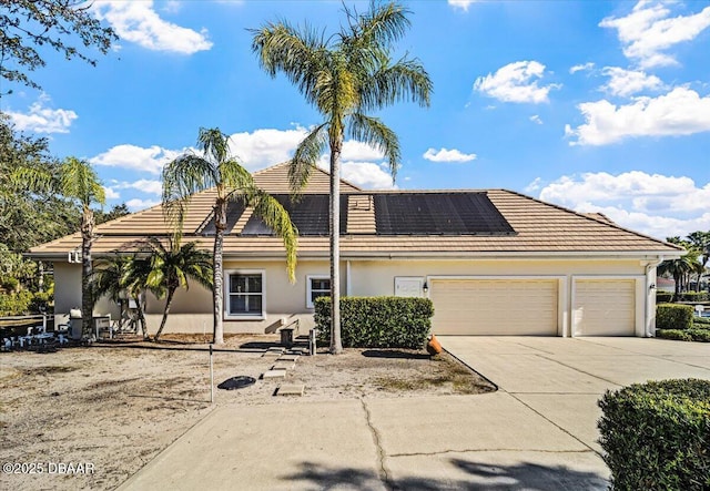 view of front of home featuring a garage and solar panels