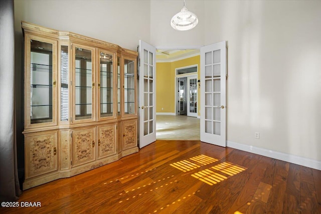 interior space featuring french doors, hardwood / wood-style floors, and a high ceiling