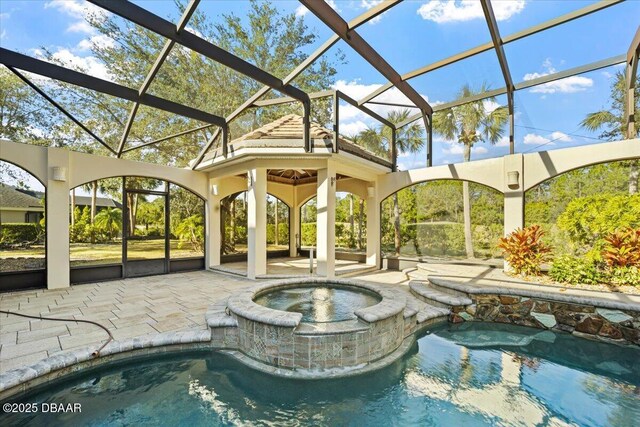 view of swimming pool featuring an in ground hot tub, a lanai, and a patio