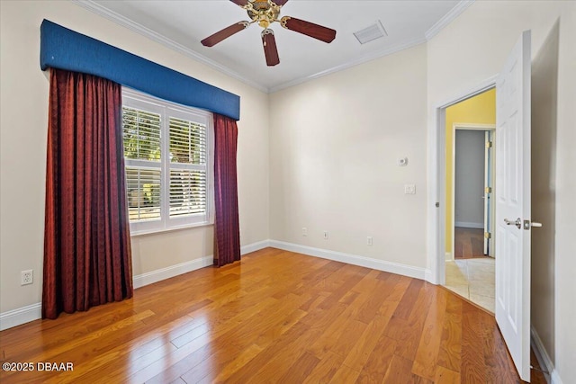 empty room with crown molding, ceiling fan, and light wood-type flooring