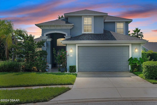 view of front of house with a garage and a yard