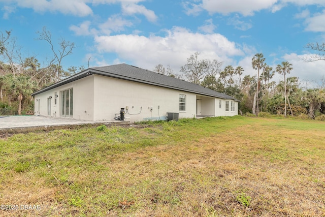 view of side of home featuring a patio, central AC unit, and a lawn