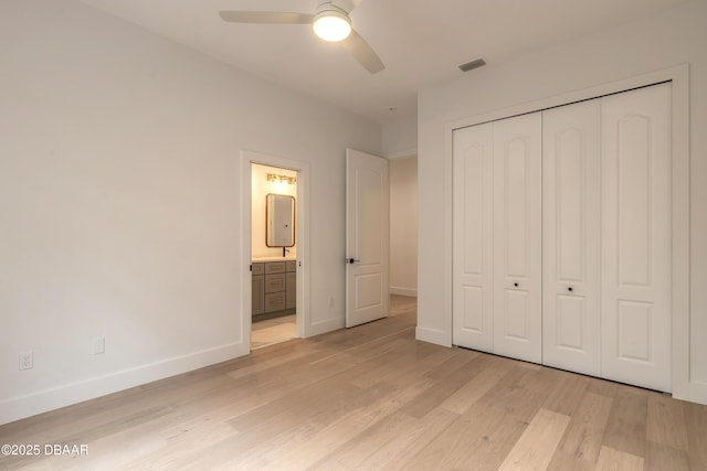 unfurnished bedroom featuring ensuite bathroom, ceiling fan, light hardwood / wood-style floors, and a closet