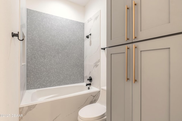 bathroom with toilet and tiled shower / bath