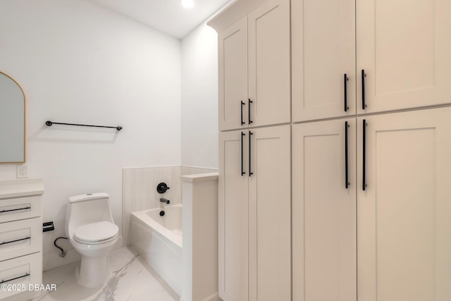 bathroom with vanity, a tub to relax in, and toilet