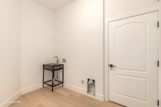 laundry room featuring hookup for a washing machine, light hardwood / wood-style flooring, and hookup for an electric dryer