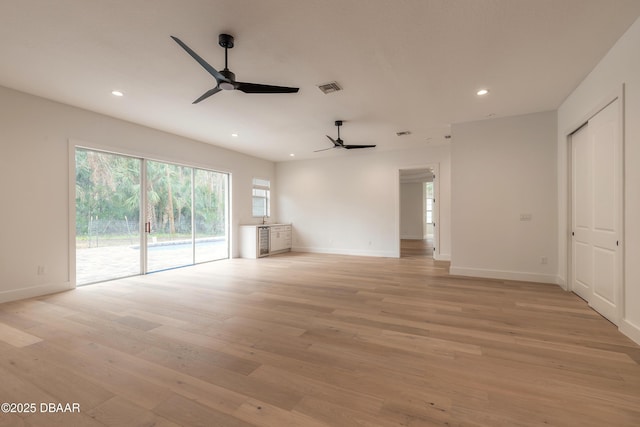 unfurnished living room featuring ceiling fan and light hardwood / wood-style flooring