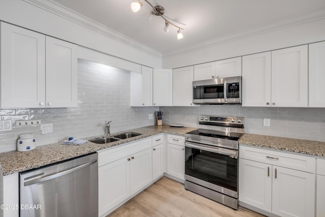 2122 S Atlantic Ave Unit 2122, New Smyrna Beach, FL 32169 - kitchen featuring appliances with stainless steel finishes, a sink, white cabinets, decorative backsplash, and crown molding