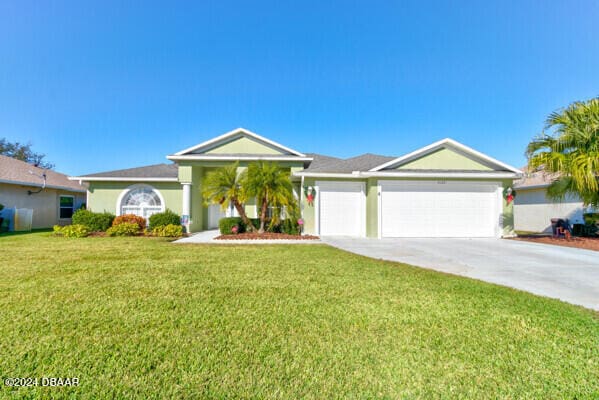 ranch-style house featuring a garage and a front lawn