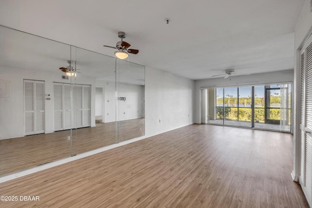 464 Bouchelle Dr Unit 104, New Smyrna Beach, FL 32169 - unfurnished living room with baseboards, wood finished floors, and ceiling fan