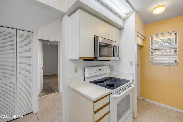 464 Bouchelle Dr Unit 104, New Smyrna Beach, FL 32169 - kitchen featuring stainless steel microwave, light countertops, white electric range, and light tile patterned floors