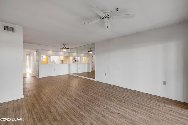 464 Bouchelle Dr Unit 104, New Smyrna Beach, FL 32169 - unfurnished living room with light wood-style flooring, visible vents, a ceiling fan, and baseboards