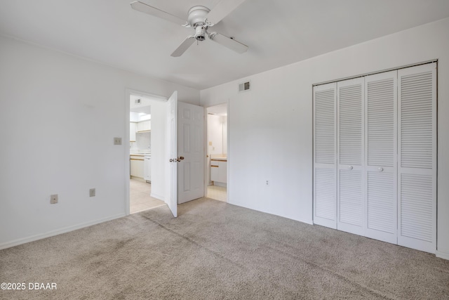 464 Bouchelle Dr Unit 104, New Smyrna Beach, FL 32169 - unfurnished bedroom featuring a closet, connected bathroom, light carpet, baseboards, and visible vents