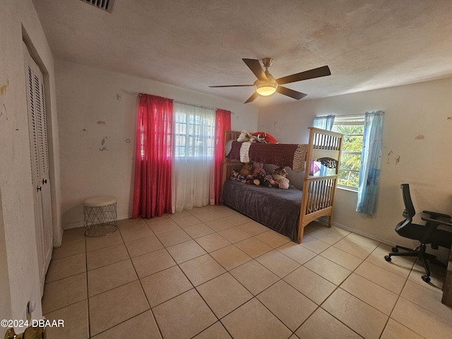 bedroom featuring light tile patterned flooring, a textured ceiling, and ceiling fan