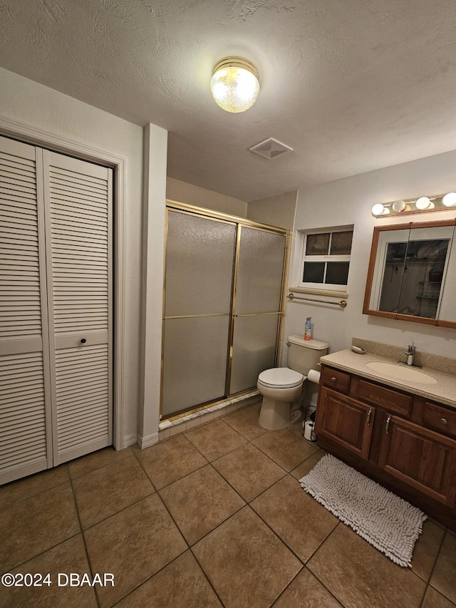 bathroom featuring tile patterned floors, visible vents, toilet, and a shower stall