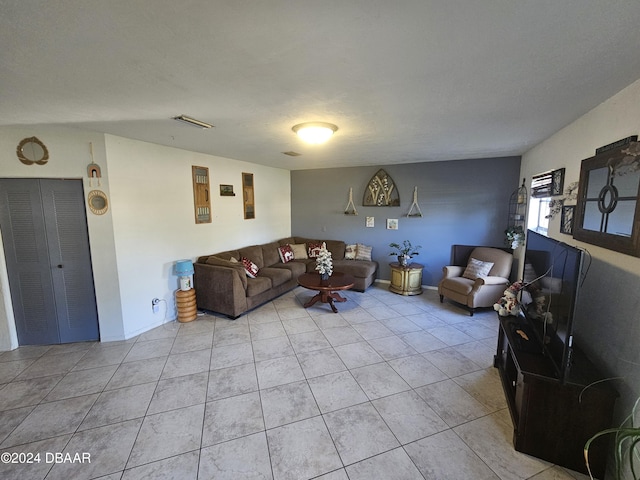 living area with light tile patterned floors, visible vents, and a textured ceiling