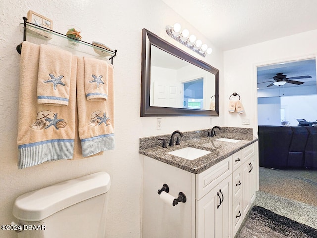 bathroom with toilet, vanity, and ceiling fan