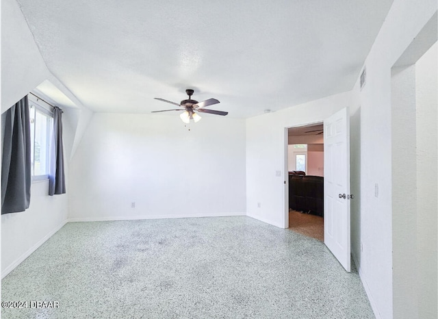 unfurnished room featuring a textured ceiling, lofted ceiling, and ceiling fan