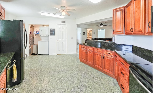 kitchen with stacked washer and clothes dryer, a textured ceiling, ceiling fan, and stainless steel appliances