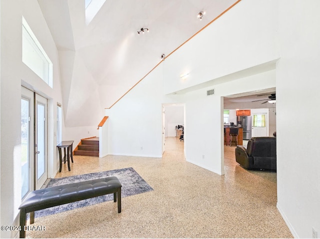 living room featuring a towering ceiling and ceiling fan