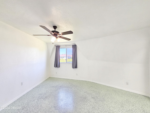 spare room with vaulted ceiling, ceiling fan, and a textured ceiling