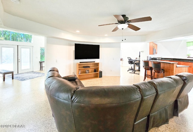 living room featuring ceiling fan and bar area