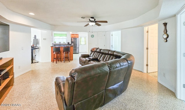 living room featuring bar area and ceiling fan