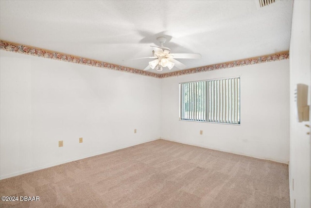 carpeted spare room featuring ceiling fan