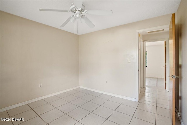 tiled empty room featuring ceiling fan