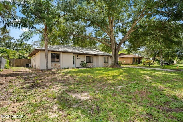 view of front of home with central AC and a front lawn